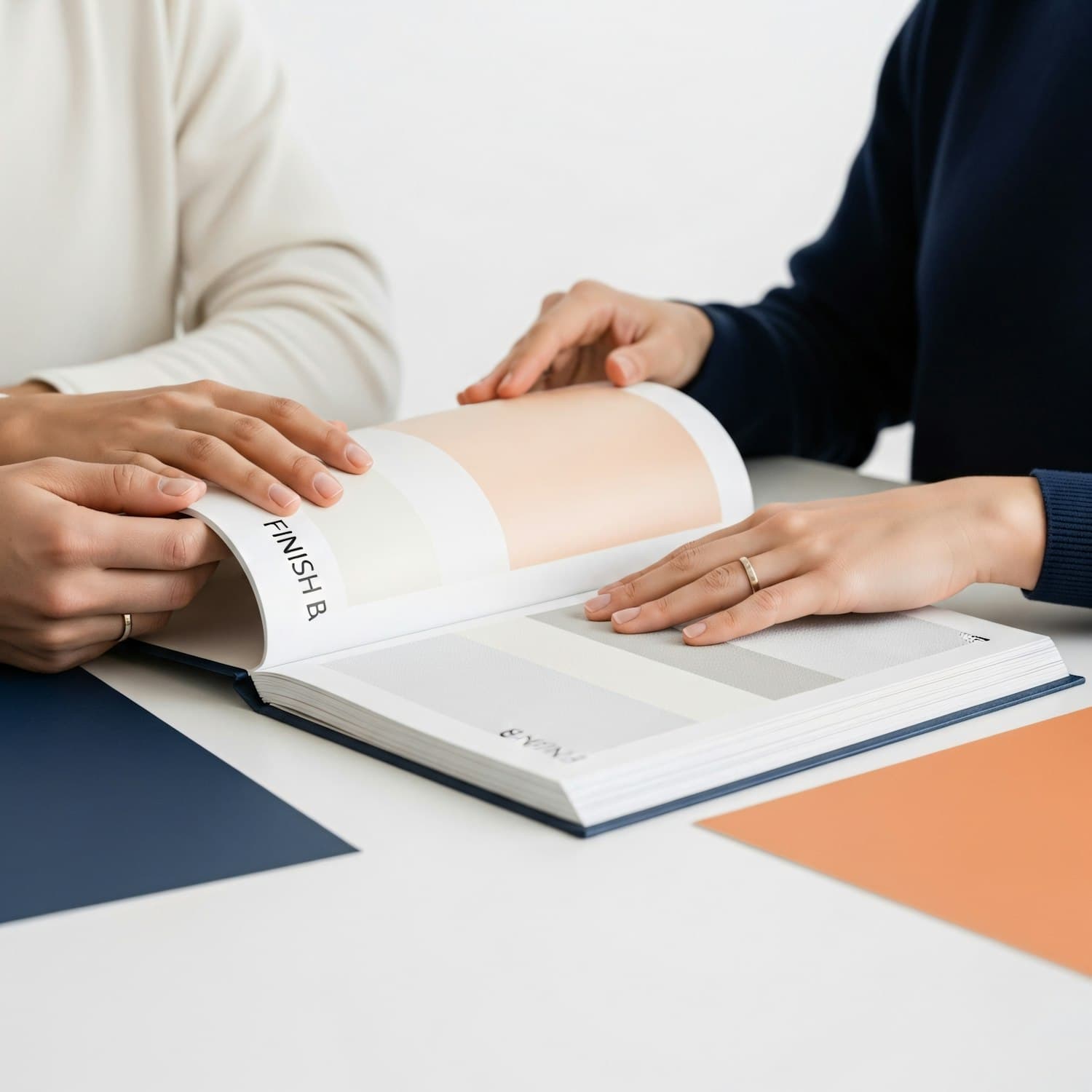 Two people comparing color swatches at a white table